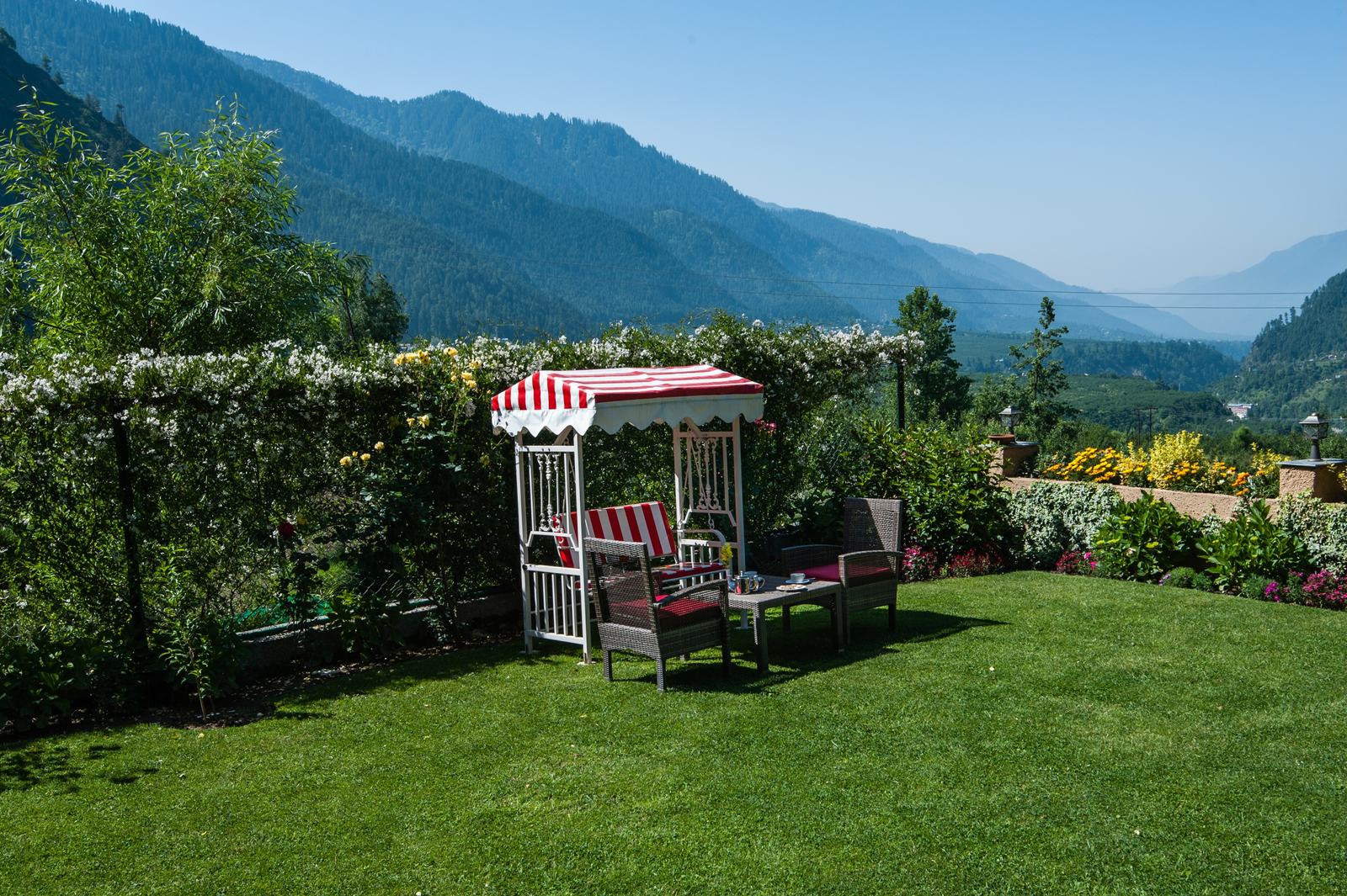 Garden swing and chairs facing the Kullu valley